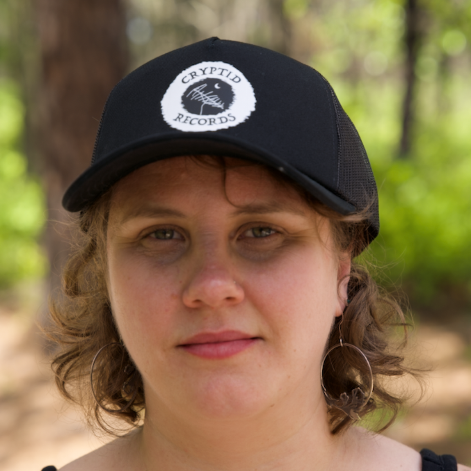 Model wearing The Beacon (Antenna) curved brim trucker hat from Cryptid Records