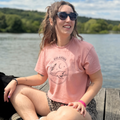 Model wearing Plesia Girl Dinner crop top in desert pink from Cryptid Records, seated