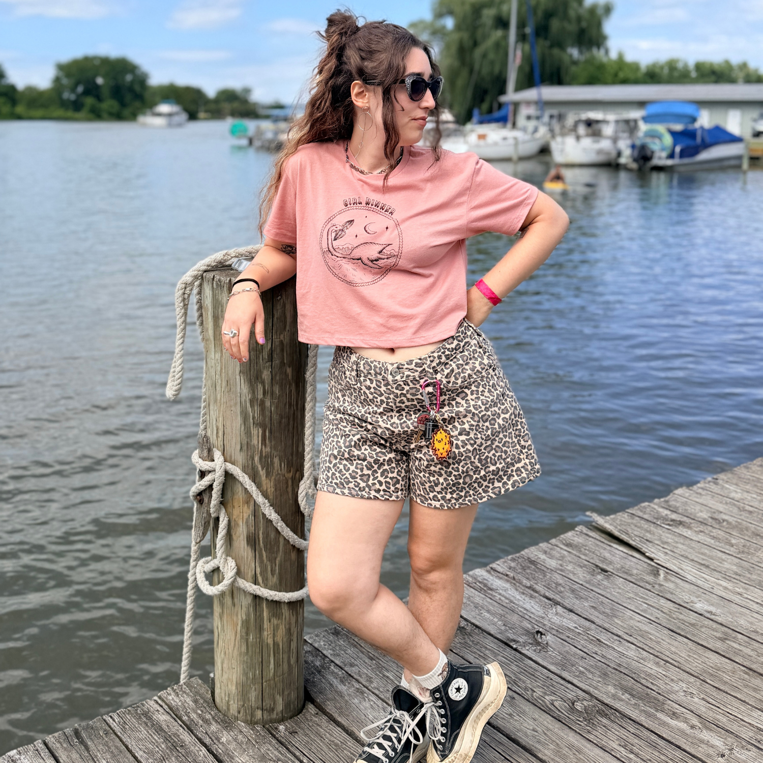 Model wearing Plesia Girl Dinner crop top in desert pink from Cryptid Records, standing
