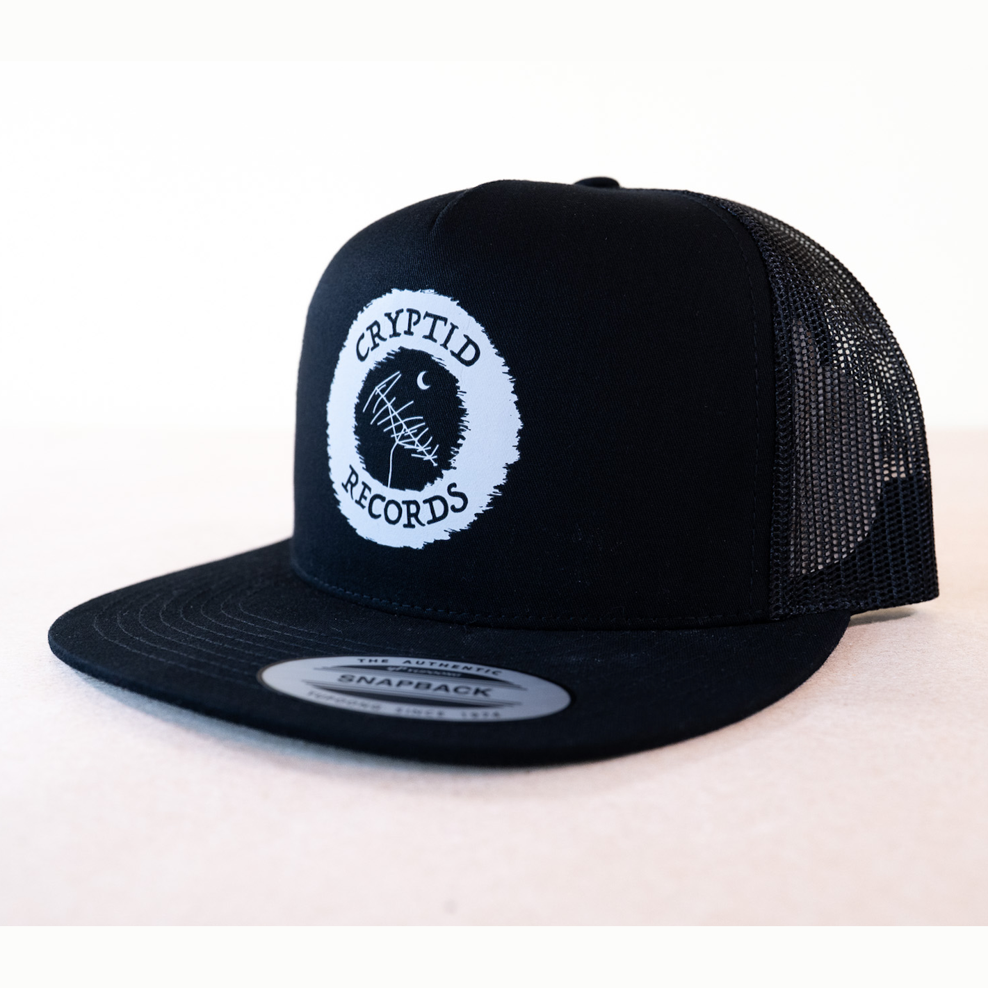 Cryptid Records logo black snapback trucker hat, side view