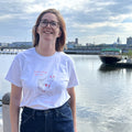 Model wearing the Sirena Fish Woman t-shirt in white at the Spruce Street Harbor Park.